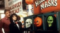 A man and woman observing Halloween masks in a store