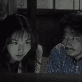 Asakawa (Nanako Matsushima) & Ryuji (Hiroyuki Sanada) examine the cursed video tape.