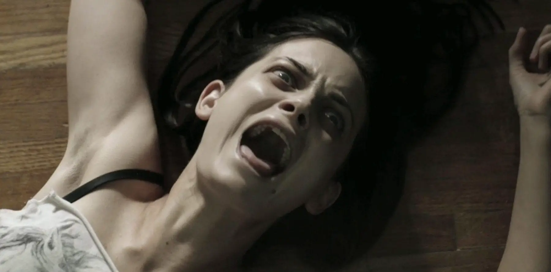 a woman screams as she's dragged across the floor