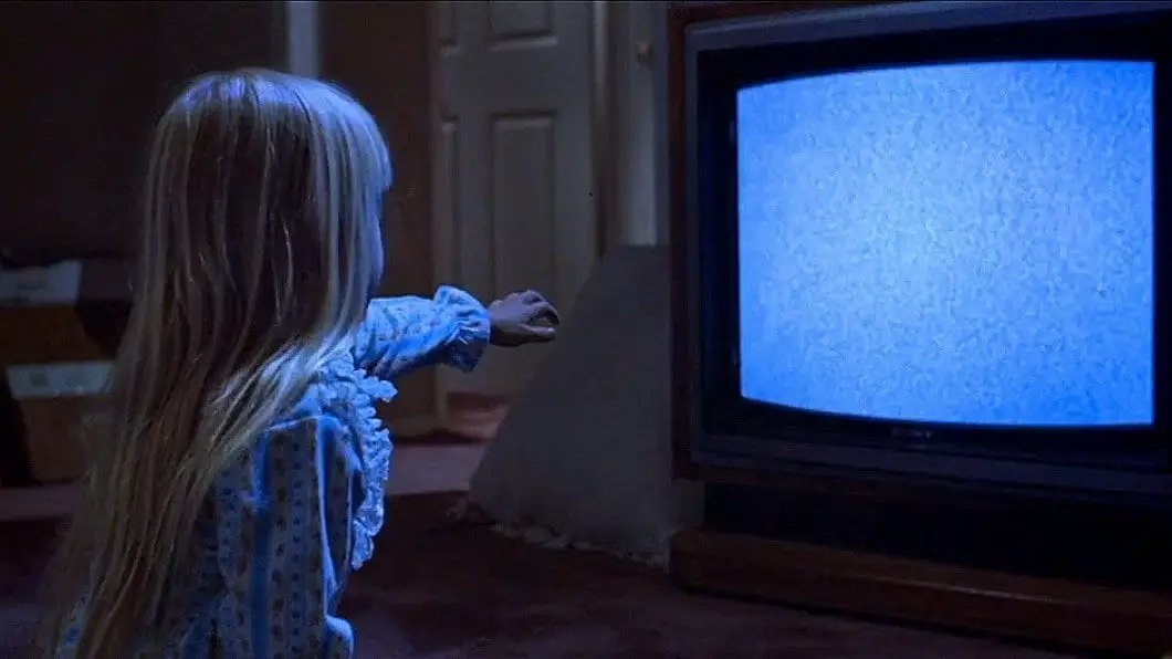 Carol Anne reaching out to a TV set in Poltergeist