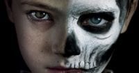 a boy with half his face painted like a skeleton