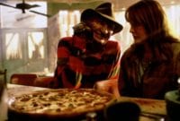 Freddy Krueger (Robert Englund) and Alice (Lisa Wilcox) share a pizza.