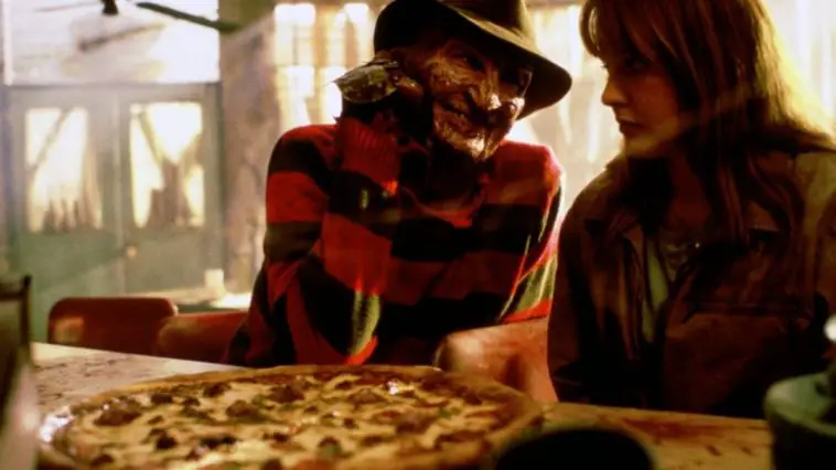 Freddy Krueger (Robert Englund) and Alice (Lisa Wilcox) share a pizza.