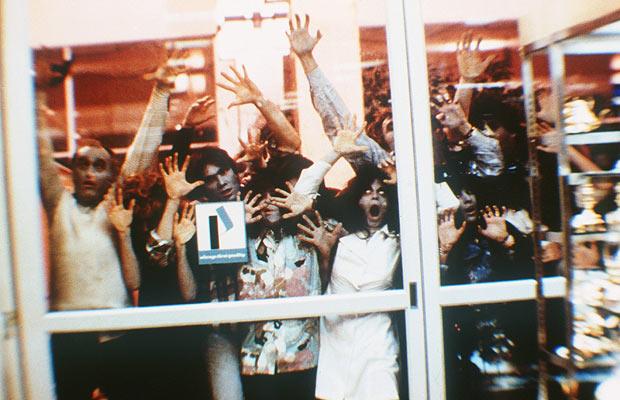 Zombies pressed against the glass door from the original Dawn of the Dead