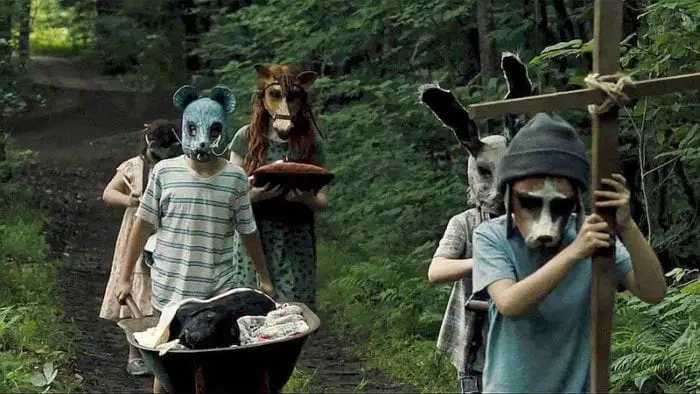 children with animal masks stare at camera
