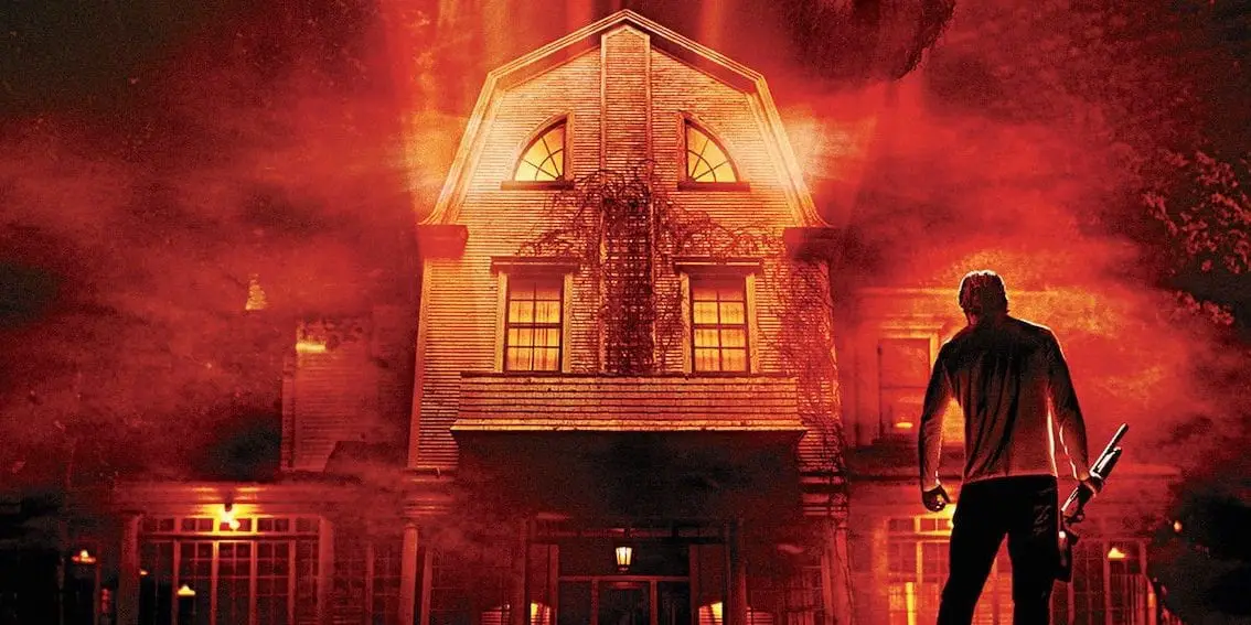 Man George Lutz stands in front of house in the remake of The Amityville Horror