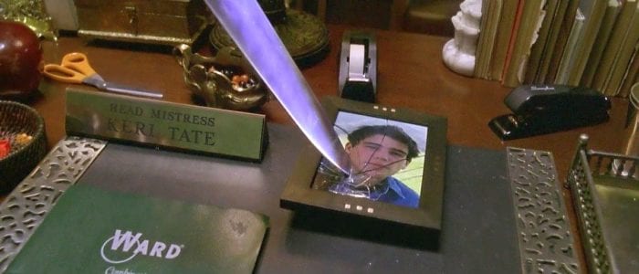 A knife shatters a photo of John Tate on the desk of Laurie Strode 