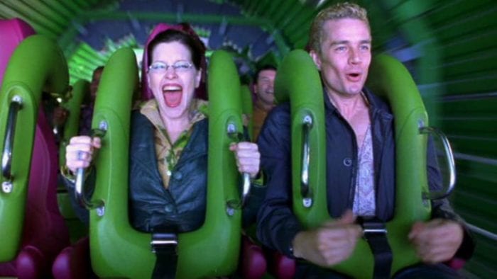 A news reporter and her cameraman enjoy a rollercoaster, the latest entertainment from amusement park mogul Stephen Price.
