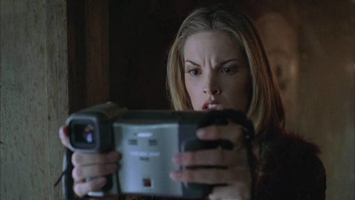 Aspiring TV show host Melissa Marr holds a camera in front of her face, looking scared by what she sees on it.