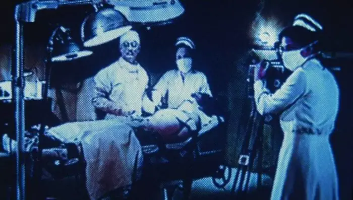 The ghosts of a former Sanitarium perform illegal surgeries on their patients, while looking up at the person filming them.