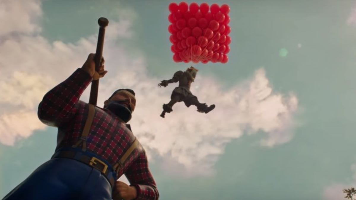 A creepy clown holds on to red balloons and floats in the sky over a statue.