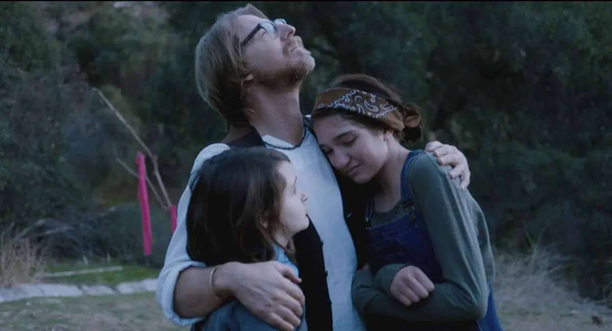 Lew Temple, Tate Birchmore, and Nicole Moorea Sherman enjoy a familial embrace in Between the Darkness (2019)