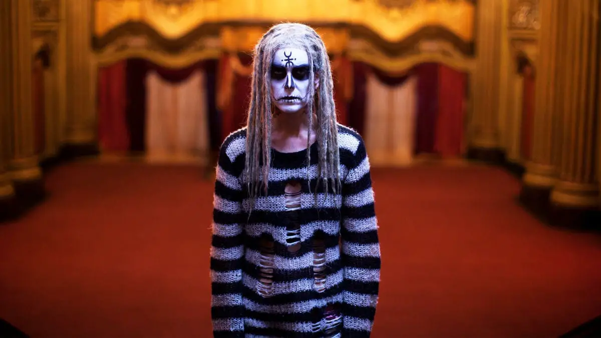 Girl with black and white striped sweater and painted goth black and white face in Lords of Salem