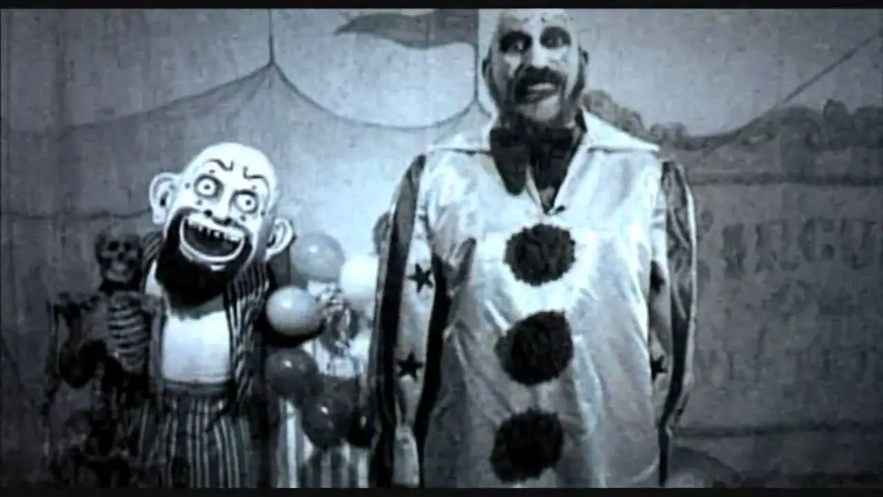 Captain Spaulding stands next to a puppet in his gas station commercial