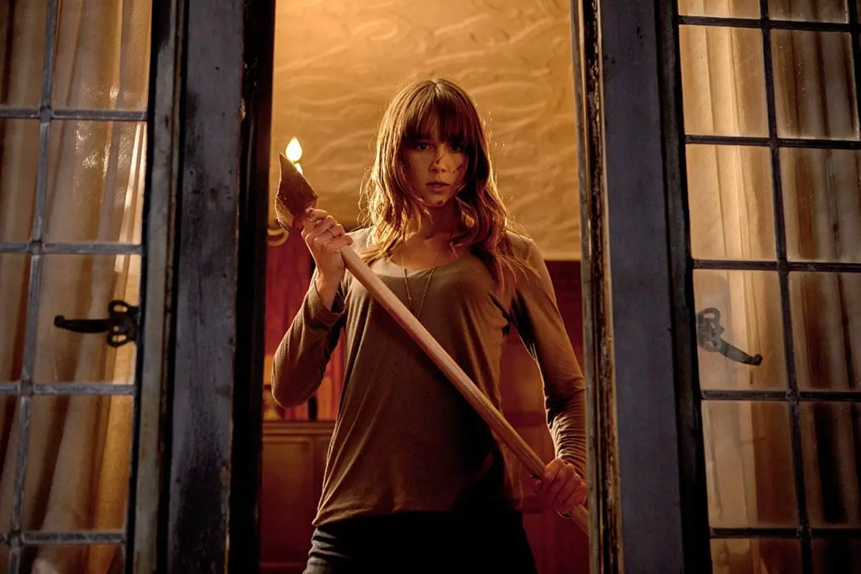 Sharni Vinston holding an axe in a doorway