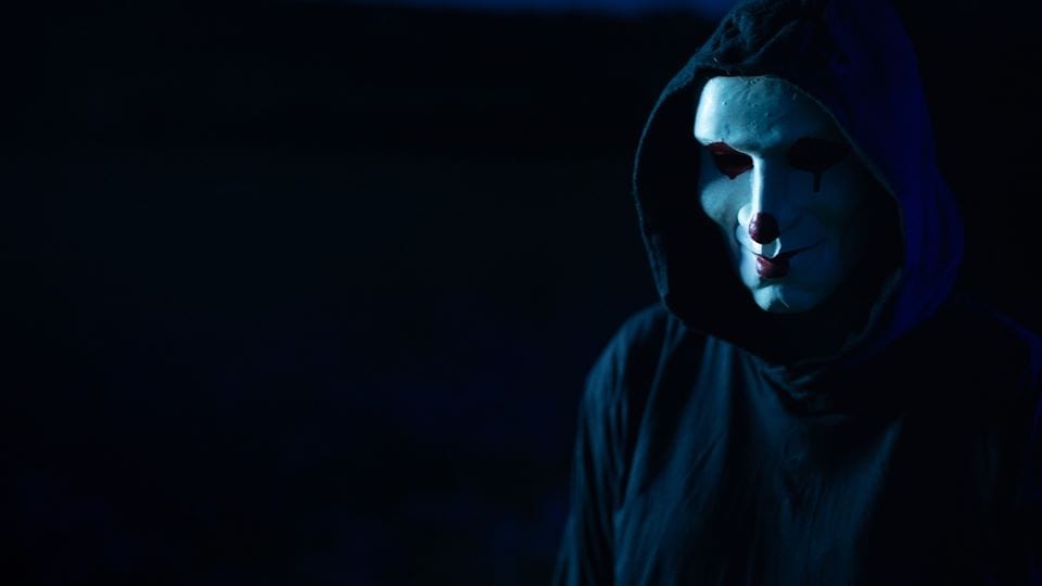 A masked character in a still from Don't Let Them In