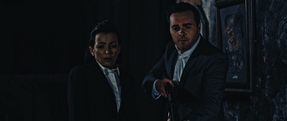 Jenna and Karl (holding a shotgun) in a still from Don't Let Them In