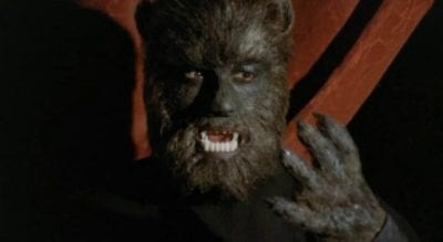 A werewolf looks at his hairy hand in disbelief