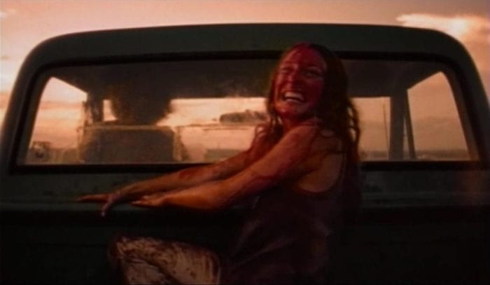 Sally hitching a ride away from a disappointed Leatherface at the end of The Texas Chain Saw Massacre.
