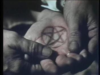 A pentagram is burned onto someone's palm.