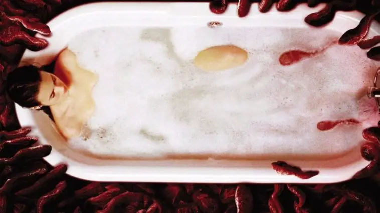 a woman in a bathtub with lots of bloodied creatures