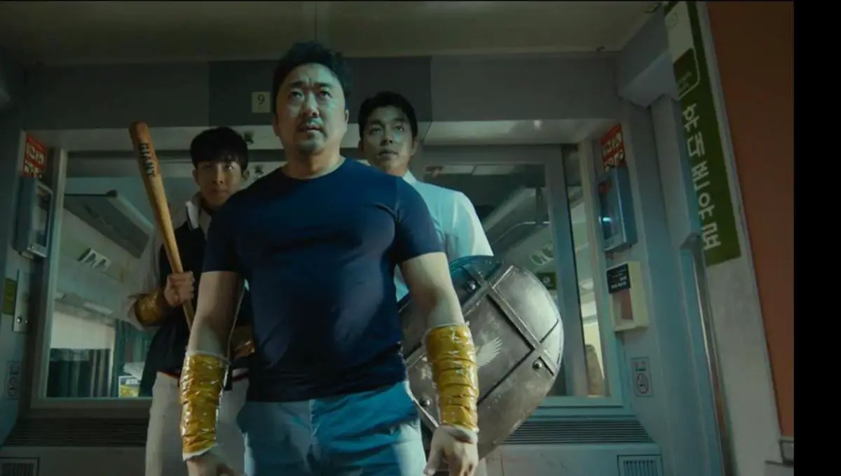 main characters sang-hwa, seok-woo and yong-guk carrying weapons, preparing to fight on the train