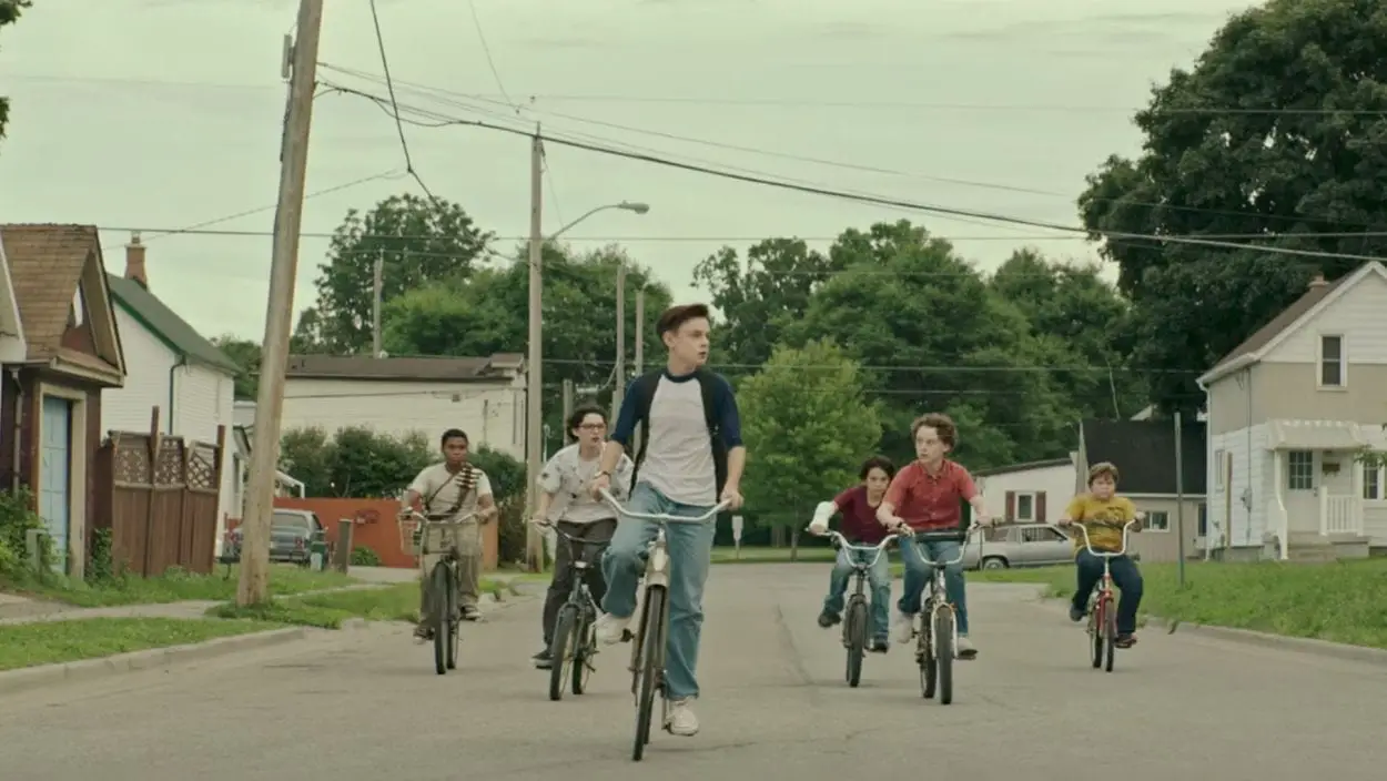 The Losers Club ride bikes down a Derry street.