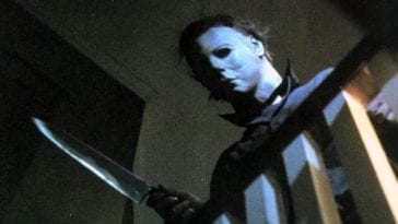 Michael Myers looking down while wielding a knife.