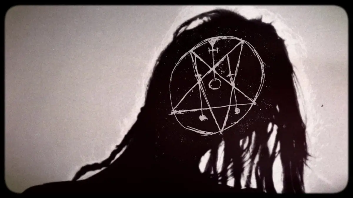 Silhouetted face with dreadlocks against a bright sky - where his face would be is a white occult sigil