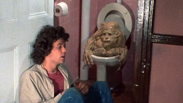 A man and a monster sit in the bathroom