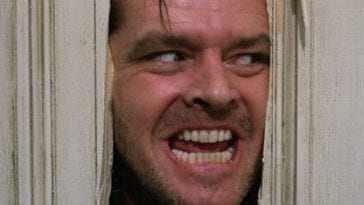 Jack Torrance peers through a broken door with a crazed look on his face