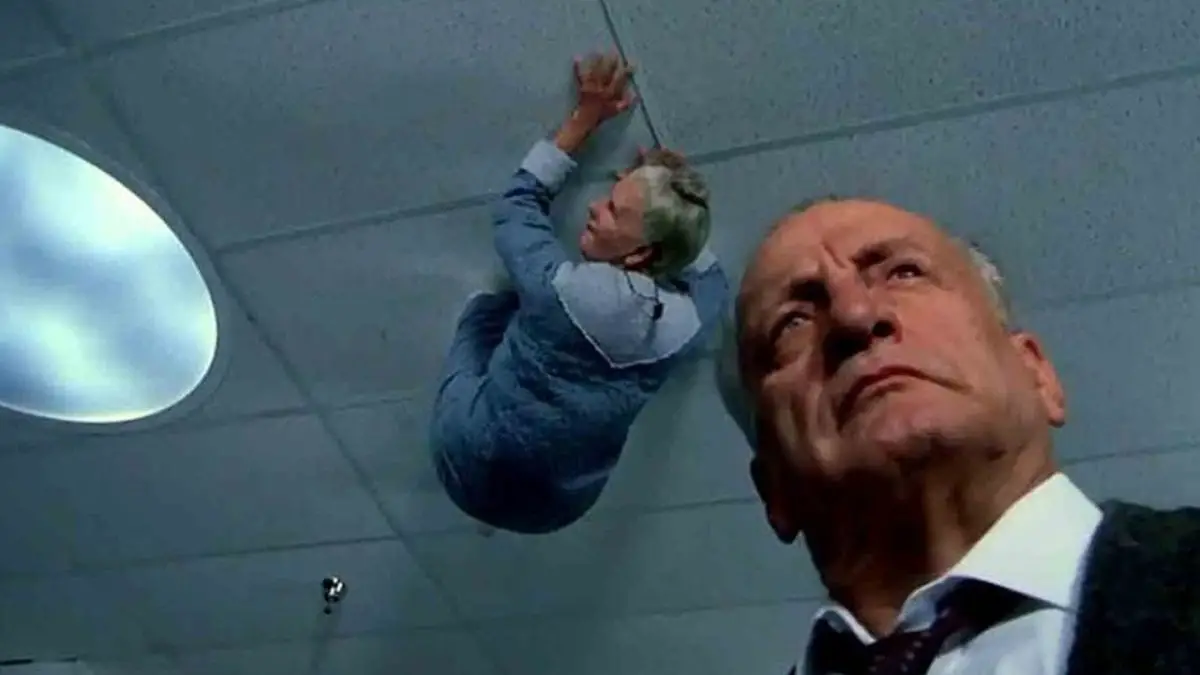 Lt. Kinderman is being watched by an old woman on the ceiling