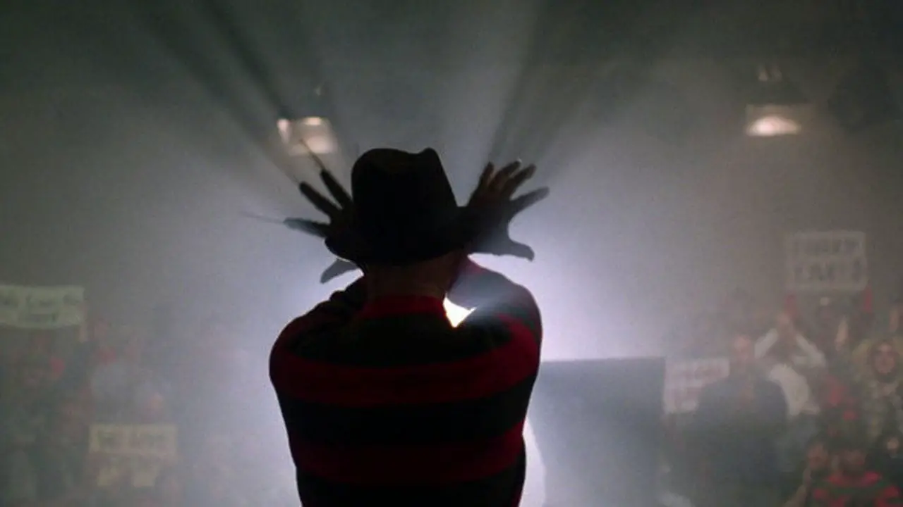 Freddy Krueger wave his arms while a spotlight shines on him