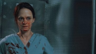 Mandy (Angela Bettis) stands in the morgue of a hospital in blood-stained scrubs.