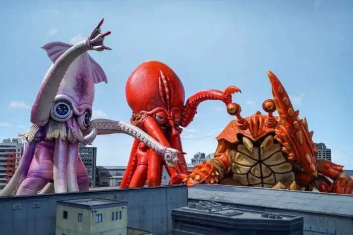 Cartoonish squid, octopus, and crab kaijus flail their limbs as they terrorize Japan.