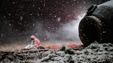 Konstantin Veshnyakov sits on the ground near Oorbiter-4 as the snow falls and blankets the area