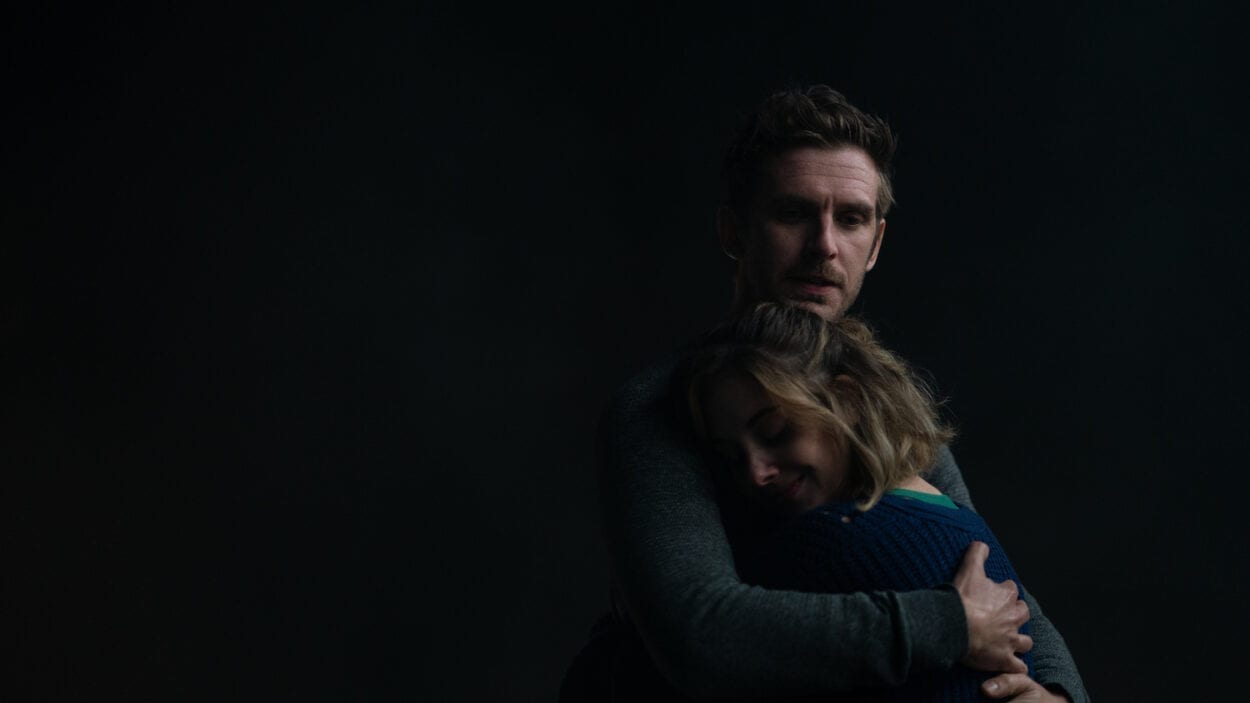 Charlie (Dan Stevens) embracing Michelle (Alison Brie) in the dark.
