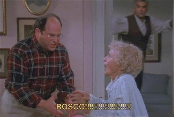A man, in plaid shirt and glasses, looks on nervously as an elderly woman in a nightgown sits up in bed, an alarmed look on her face and crying out, while in the background another man looks on, concerned,from inside the doorway. The text at the bottom of the screen reads "Bosco!!!!!"