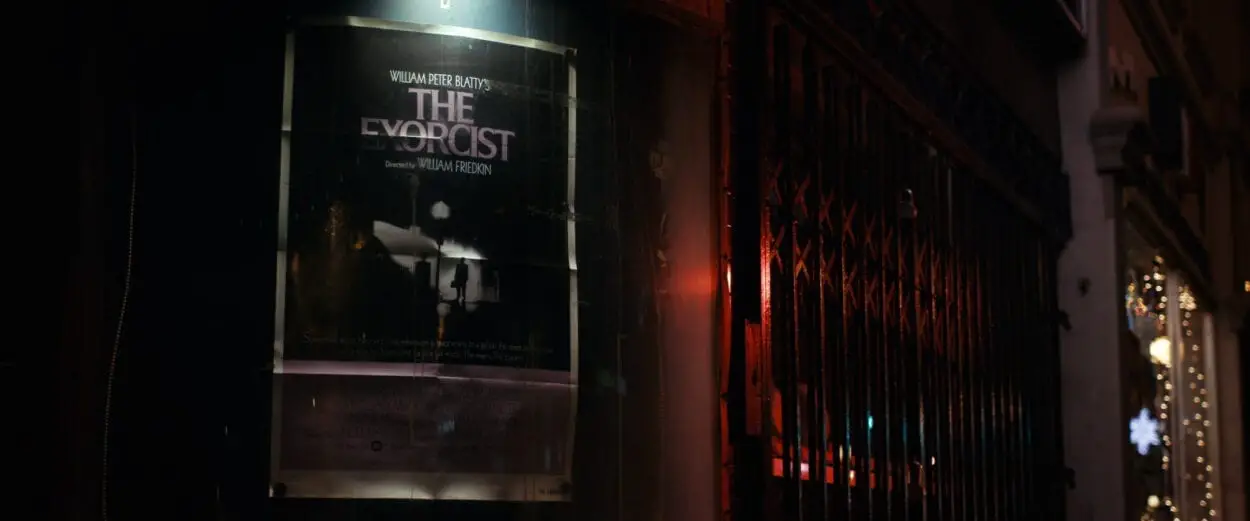 A promotional poster for The Exorcist on the side of a building late at night.