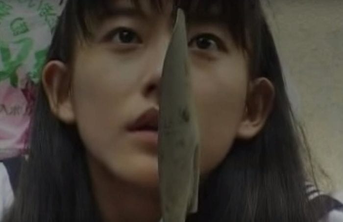Hisayo holds up a garden shovel in self defense.