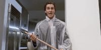Patrick Bateman wields an axe while wearing a rain cover