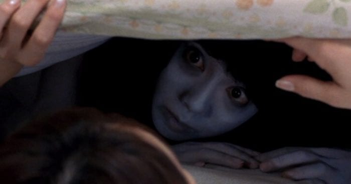 Kayako surprises her victim under the covers.