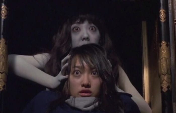 Kayako grabs Izuma from behind and drags her into the armoire.