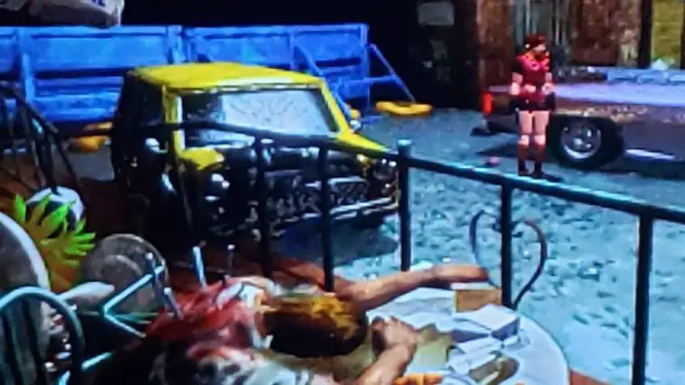 Claire wanders the desolate streets of Raccoon City. Surrounded by destruction and death. A man is dead slumped over at a table.