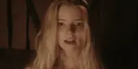 Close up of a young woman with long blonde hair, and blood on her face and neck.