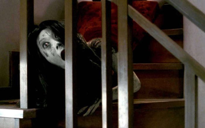 Kayako crawls and jitters down the stairs in Ju-On: the Grudge