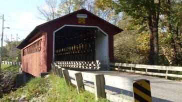 A red covered bridge in a rural area.