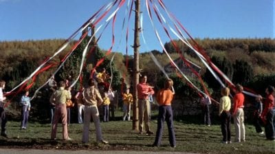 People stand around a Maypole holding ribbons in The Wicker Man.