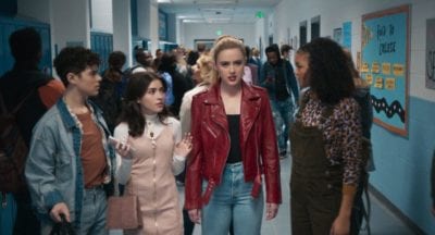 Millie walks between surprised classmates down a hallway