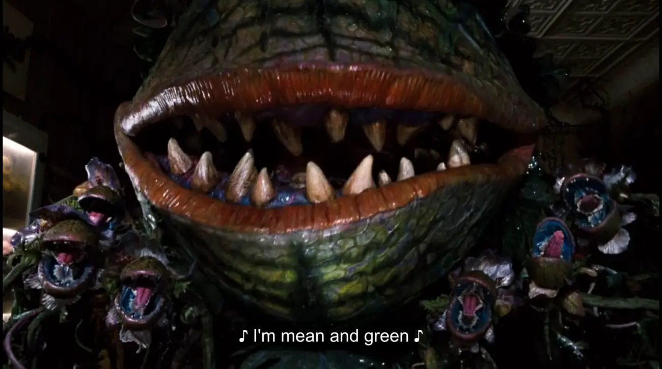 Carnivorous plant Audrey II (Levi Stubbs) and a series of carnivorous plant buds sing, "I'm mean and green," in the film, "Little Shop of Horrors" (1986).